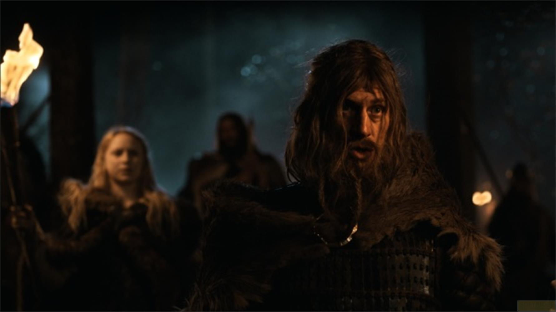 Homme barbu et torche, femme blonde en arrière-plan.