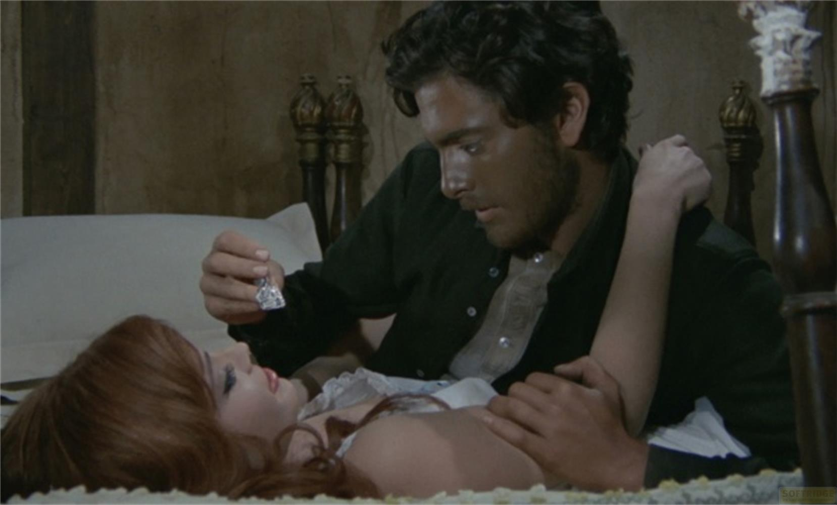 Un uomo offre un gioiello a una donna a letto.