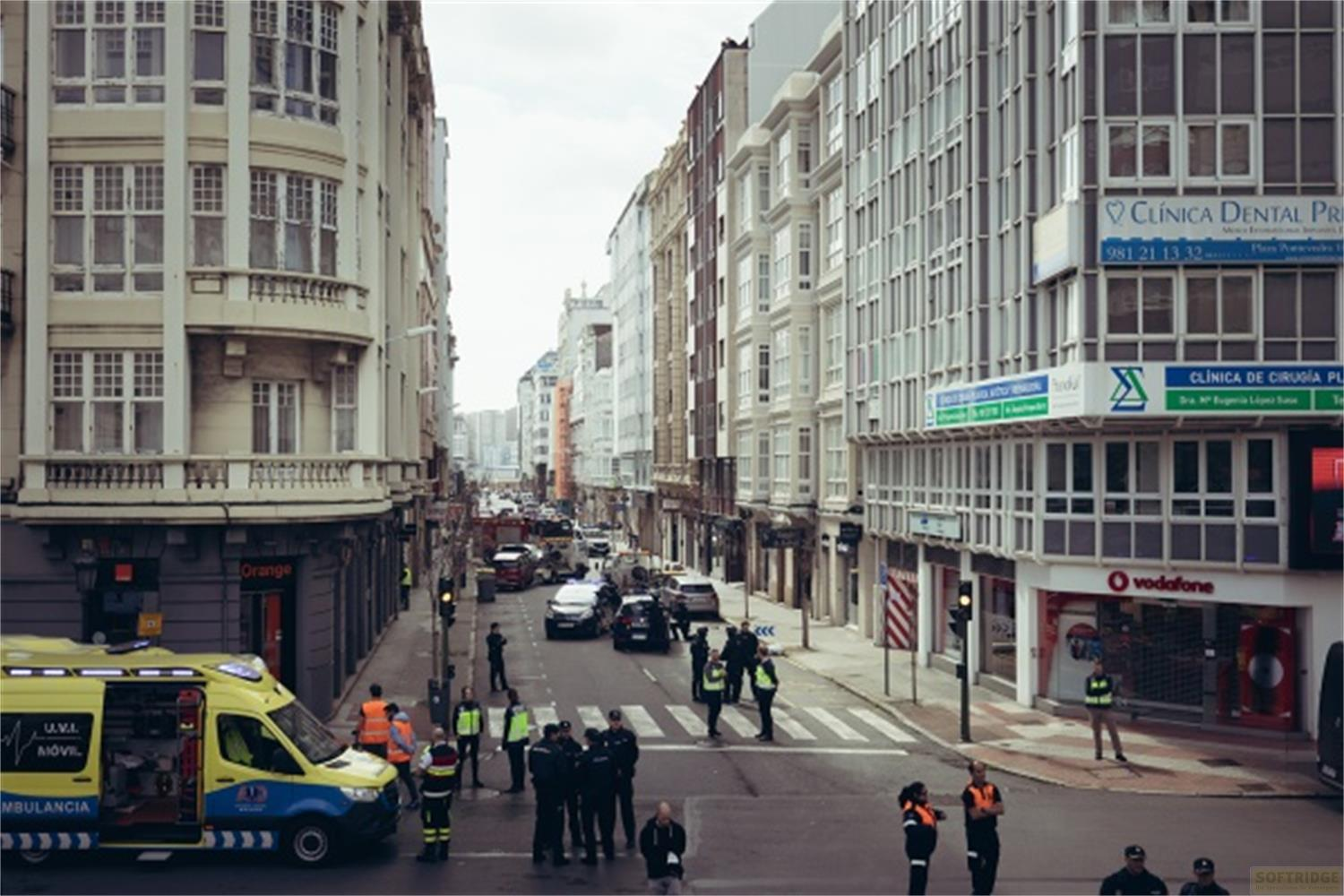 Ambulanza gialla e polizia in una strada con edifici. Scena di emergenza.