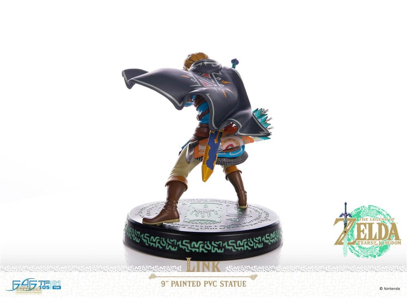 Estatua de Link de Zelda, con capa oscura y carcaj, sobre base negra.