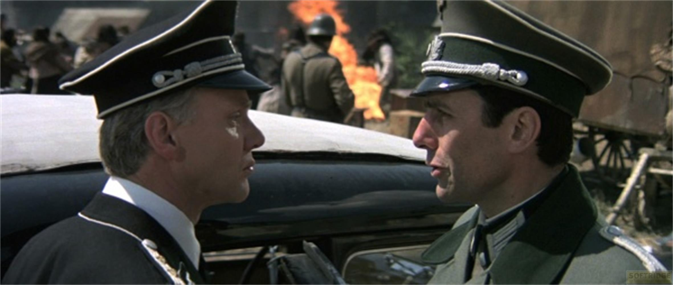 Due uomini in uniforme vicino a un'auto. Fuoco sullo sfondo.
