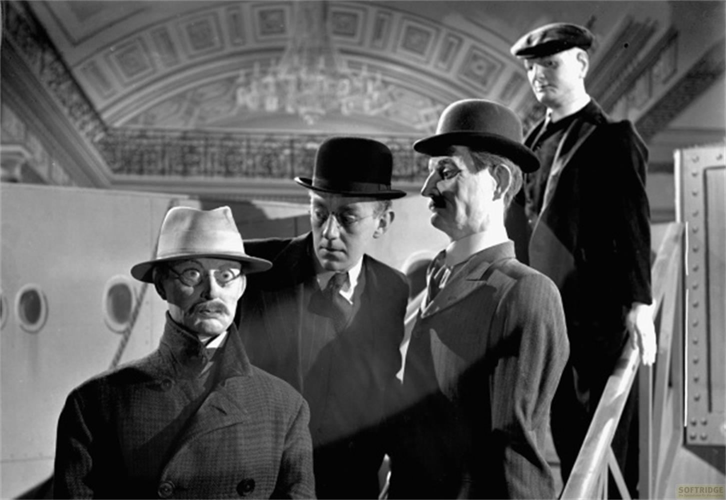 Quattro uomini in abito e cappello stanno insieme. Uno indossa un fedora.