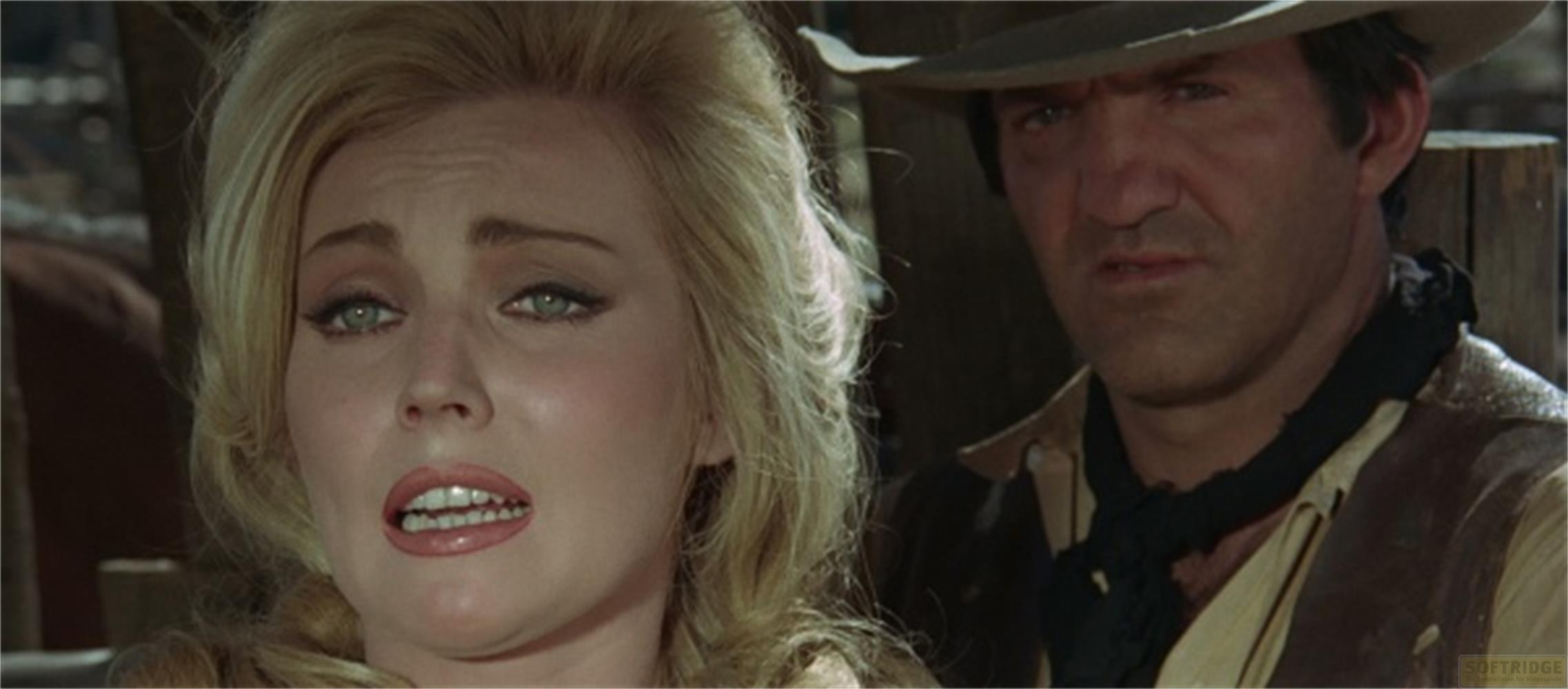 Una donna bionda e un uomo con cappello in una scena western.