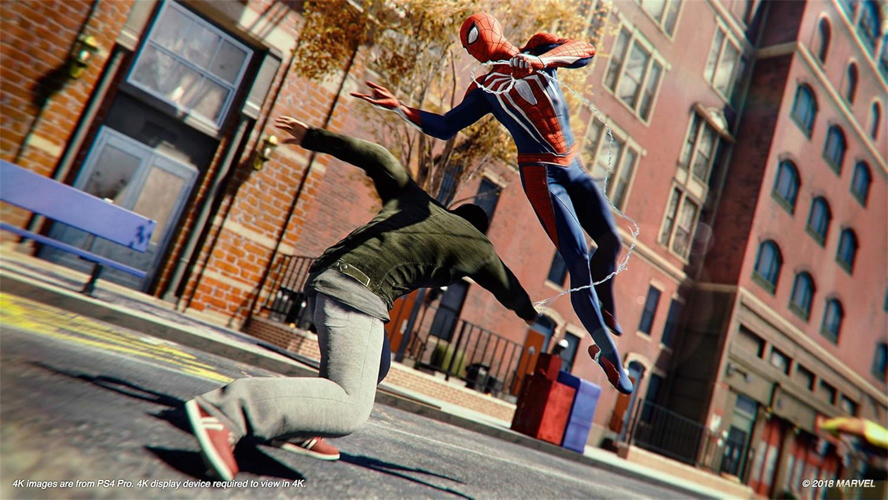 Spider-Man springt in Aktion, während ein Mann auf der Straße kauert. Gebäude im Hintergrund.