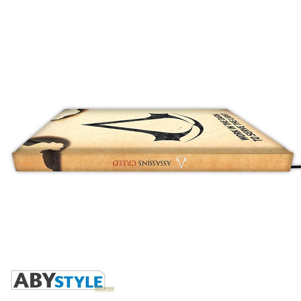 Ein Buchrücken mit dem Assassins Creed-Logo und dem Schriftzug "Work in the dark to serve the light".