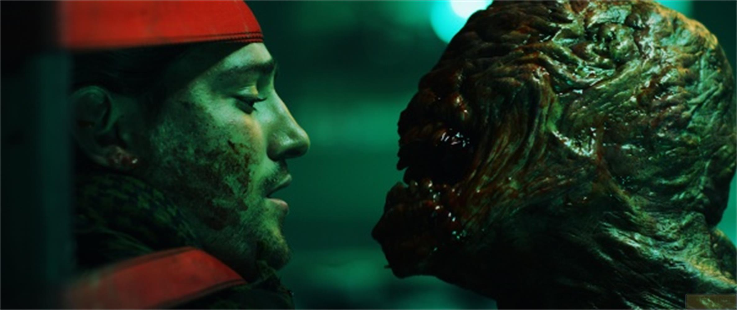 Un uomo con copricapo rosso guarda una creatura mostruosa.
