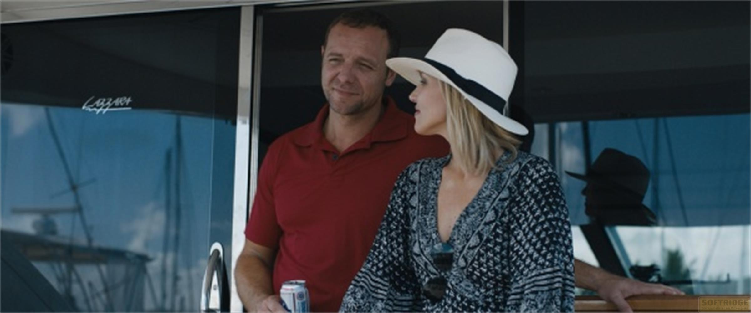 Uomo in polo rossa e donna con cappello bianco su uno yacht.
