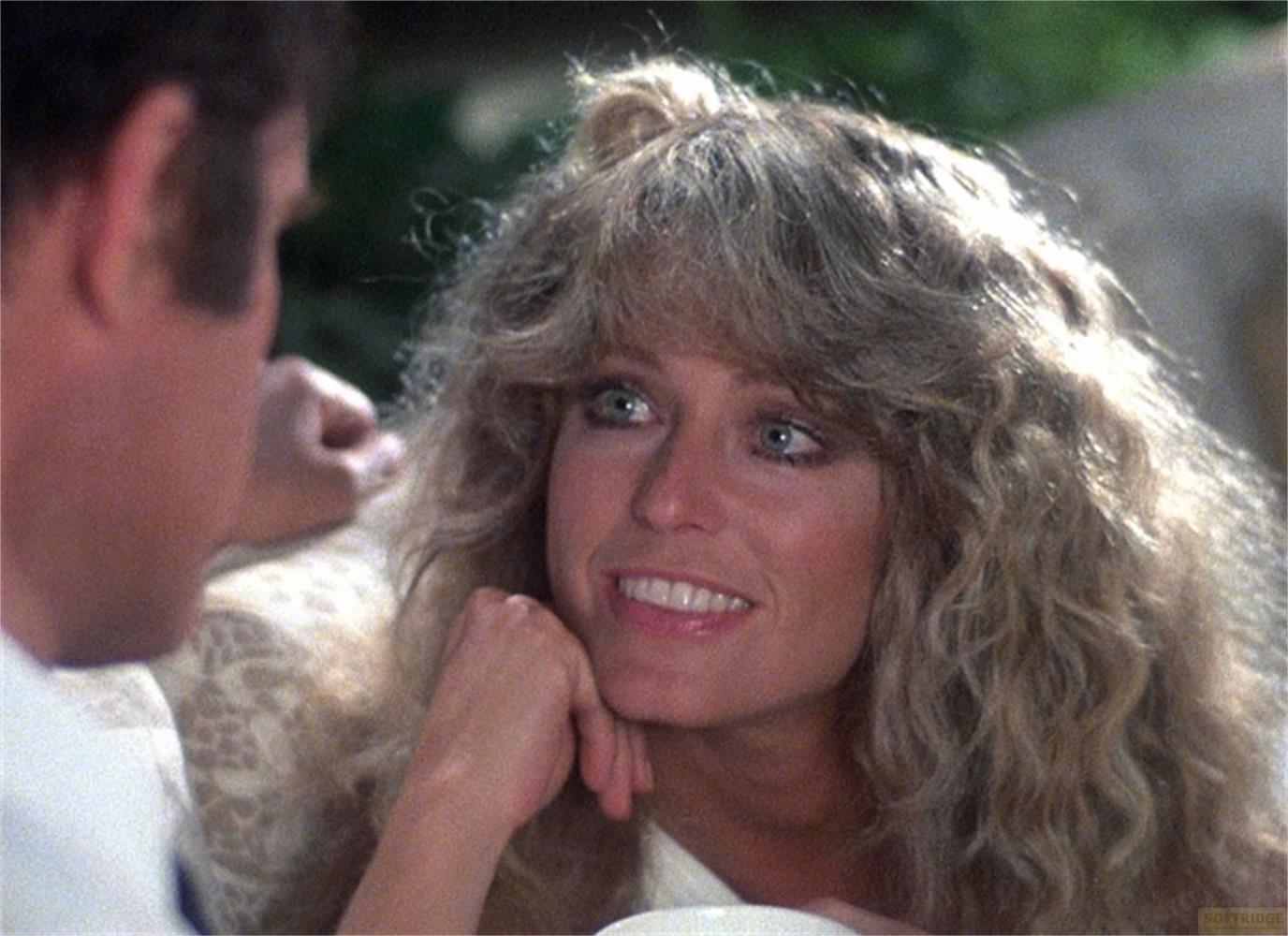 Una donna con capelli lunghi e mossi guarda un uomo sorridendo.