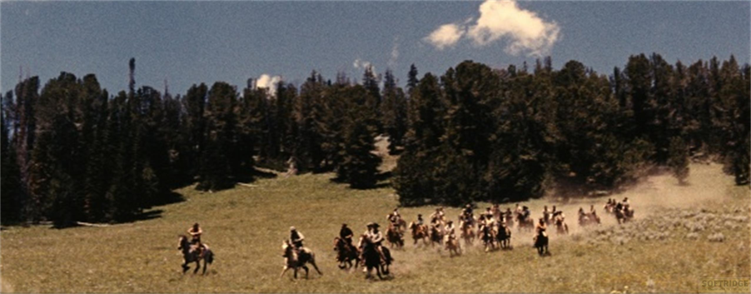 Un gruppo di cavalieri attraversa un prato soleggiato con alberi sullo sfondo.