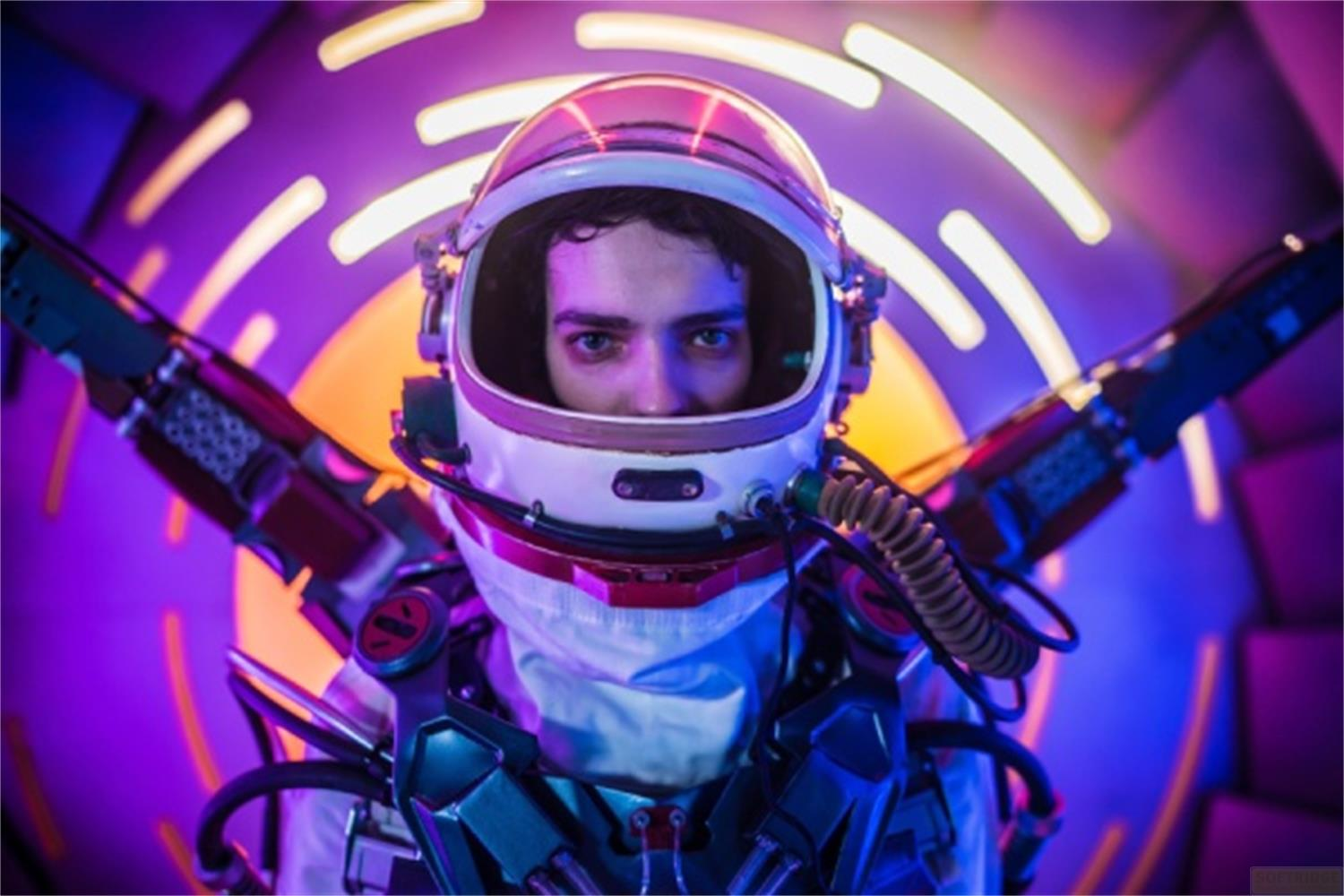 Un astronauta con casco guarda attraverso la visiera, circondato da luci al neon.