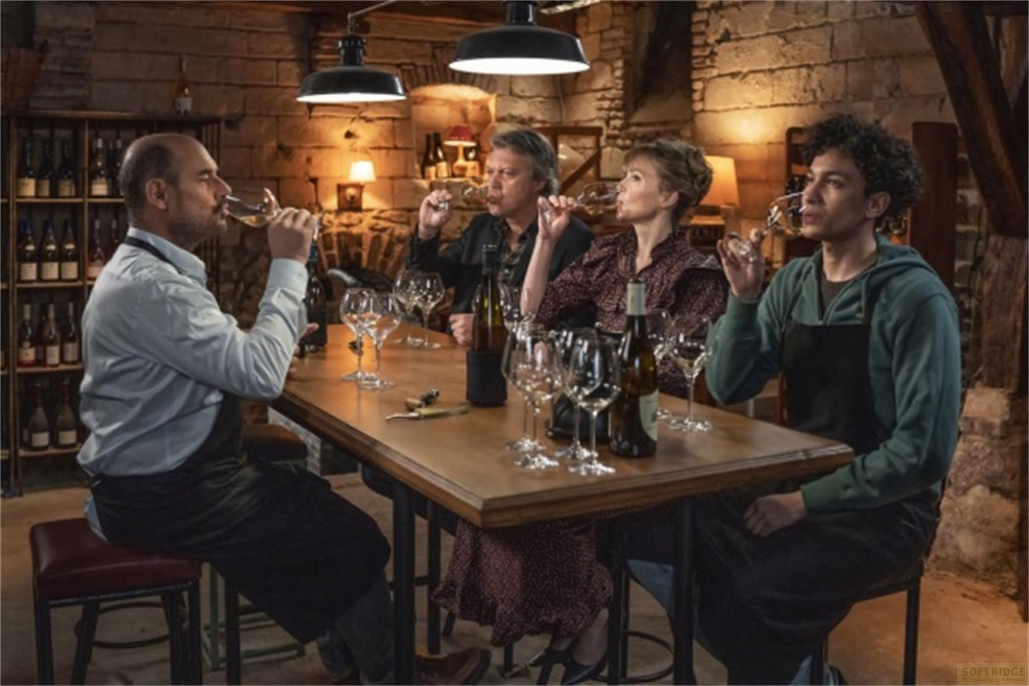 Quattro persone degustano vino in una cantina rustica con rastrelliere.