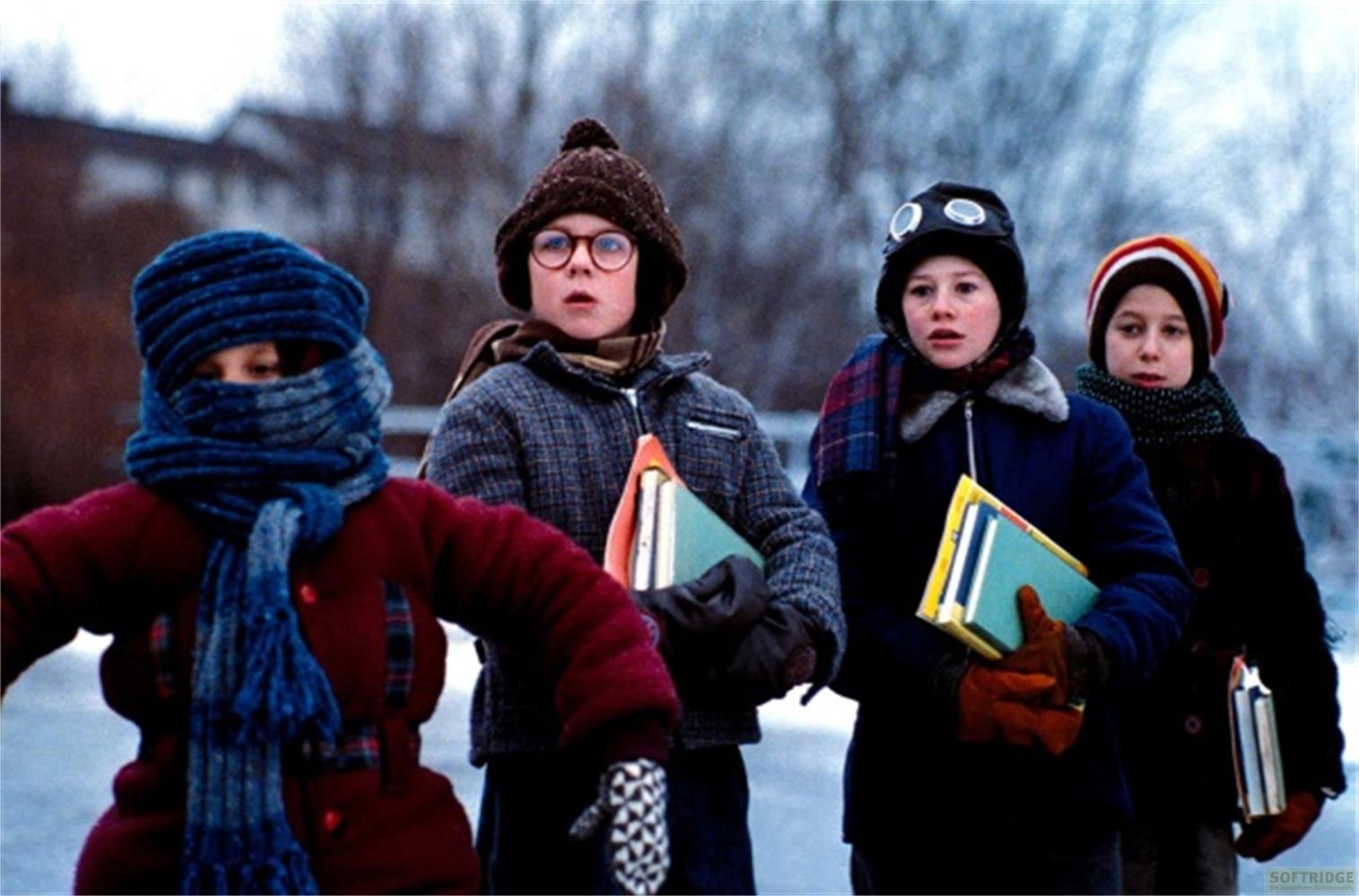 Quattro bambini in abiti invernali stanno fianco a fianco.