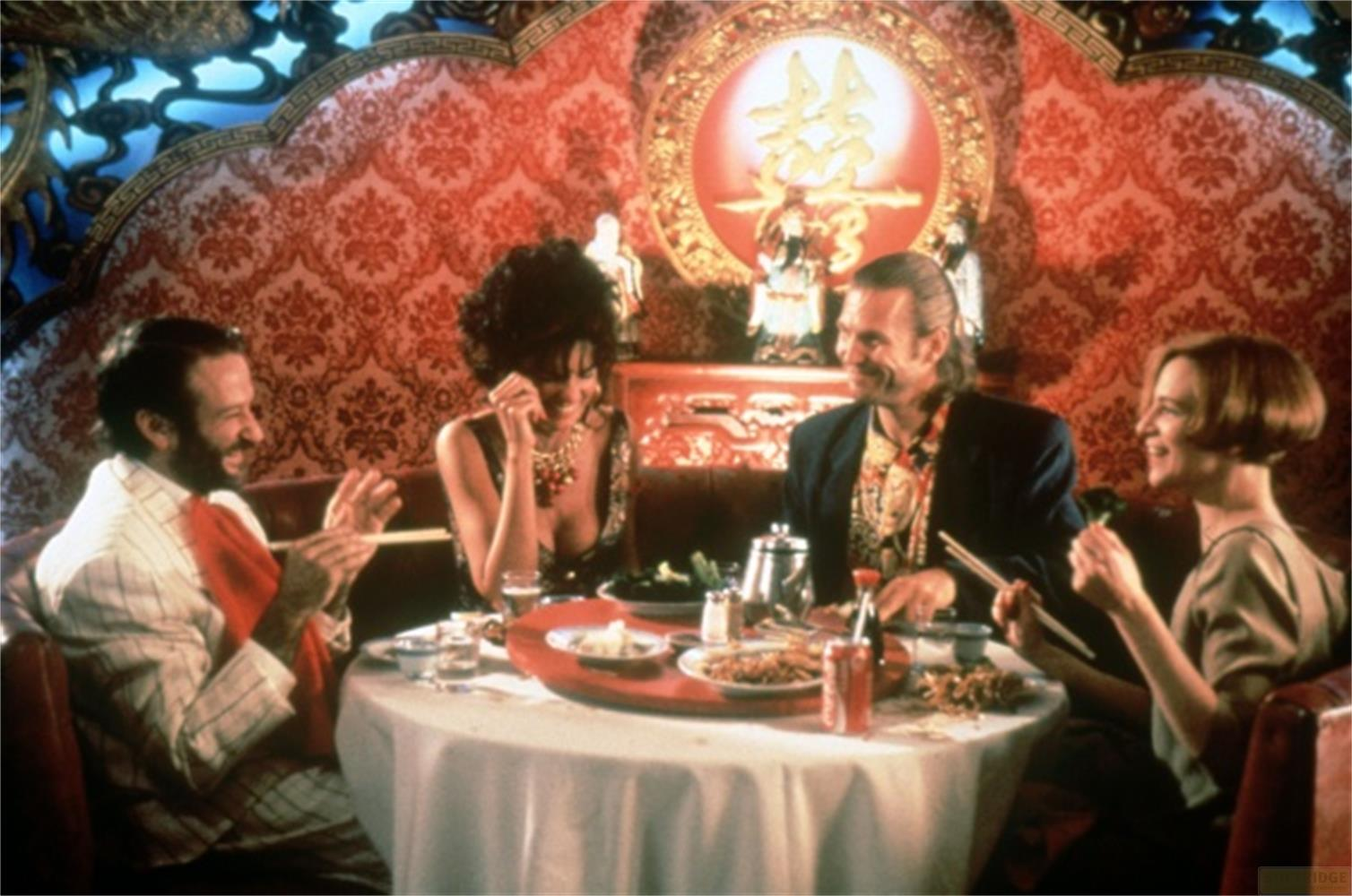 Quatre personnes dînent à une table ronde dans un restaurant chinois opulent.