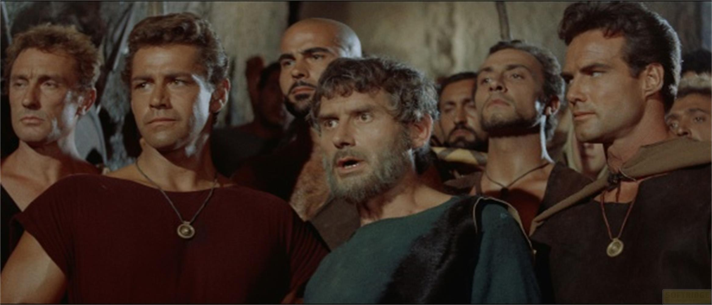 Un gruppo di uomini con barba e capelli corti, che guardano a sinistra.