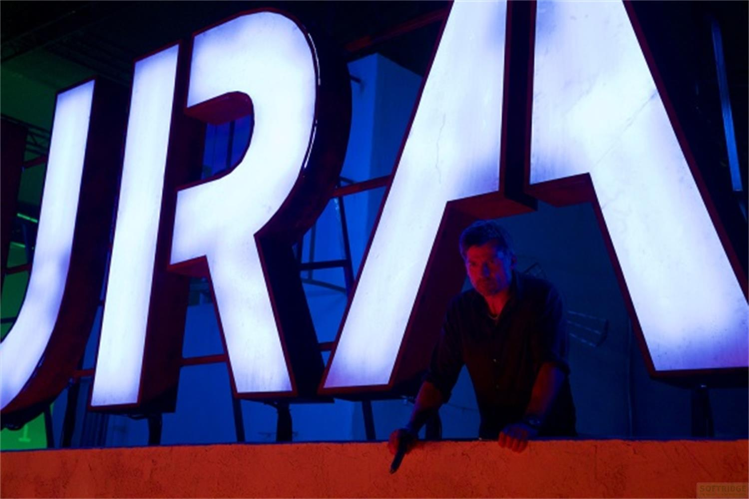 Uomo dietro lettere illuminate. Base rossa. Luci blu e verdi.