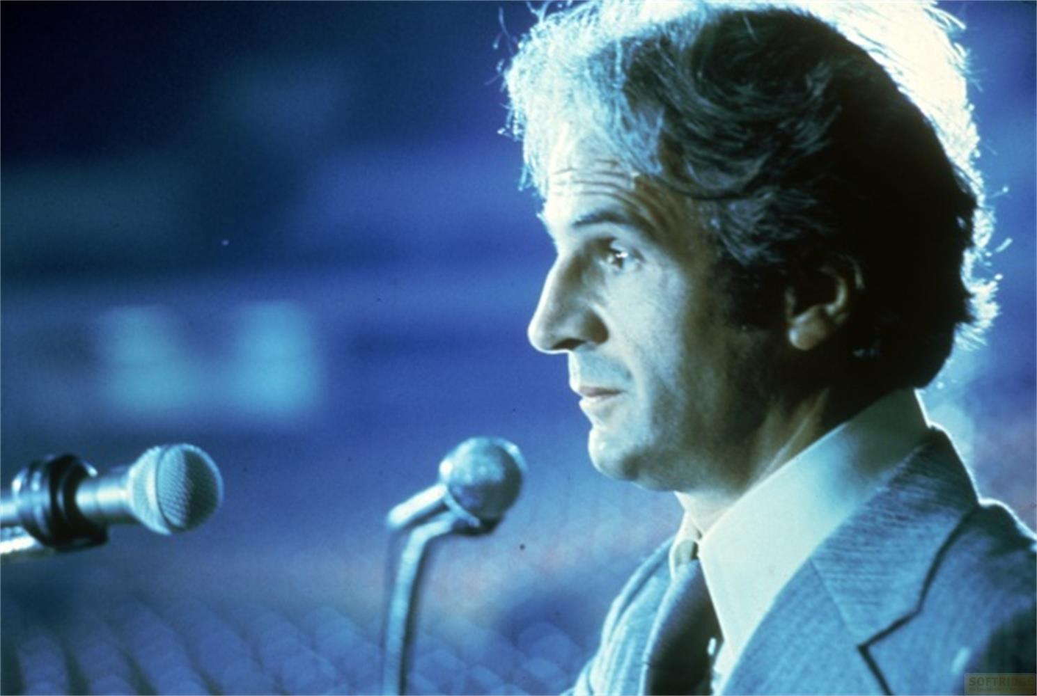 Homme de profil avec des microphones, rétroéclairage bleu, costume.