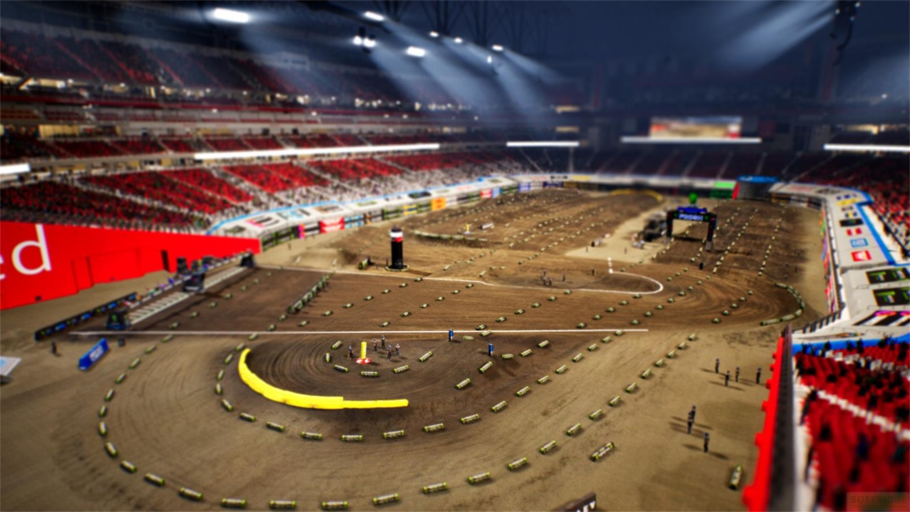 Una pista di motocross in uno stadio con spalti e luci.