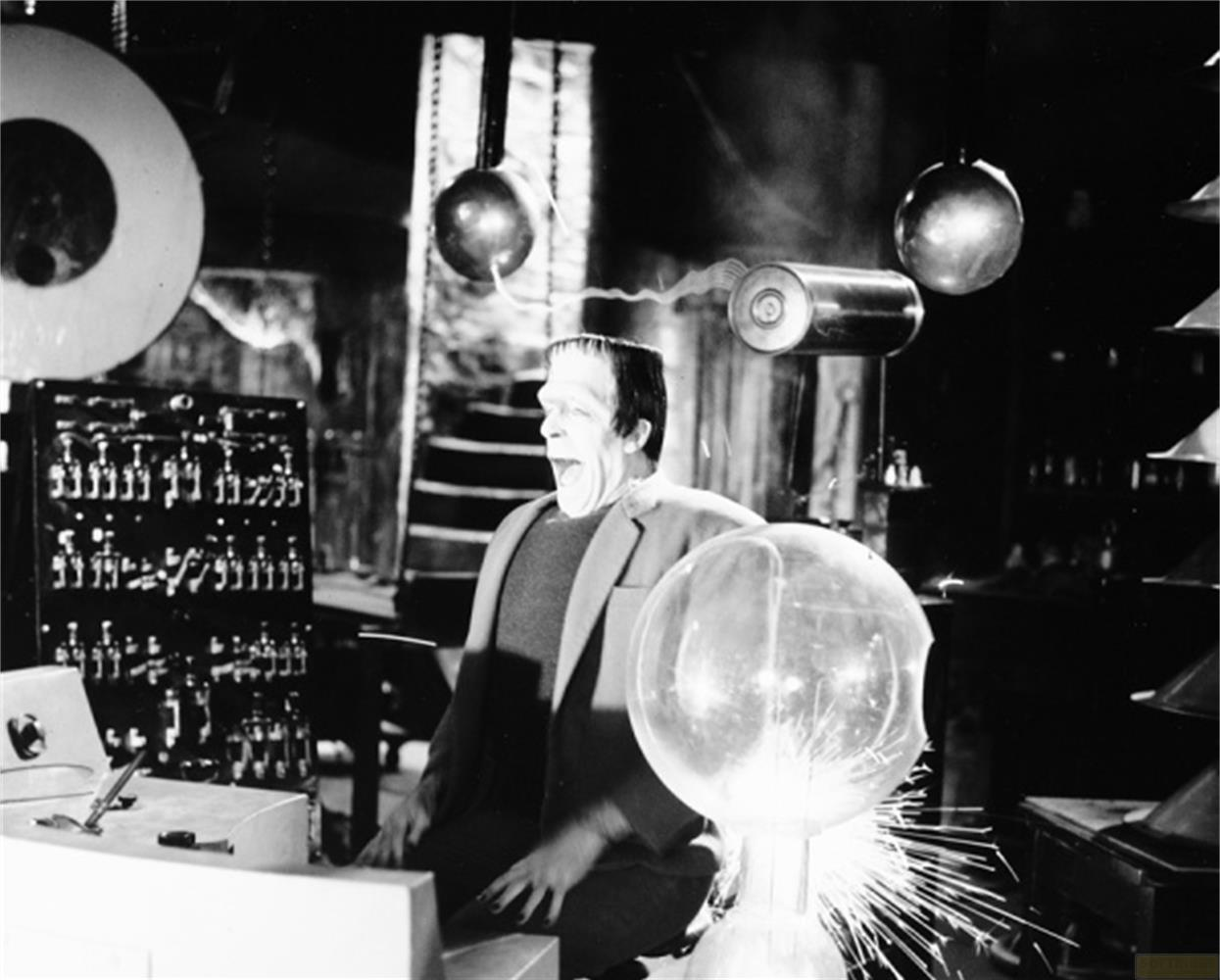Frankenstein con la bocca aperta in un laboratorio pieno di apparecchi e scintille.