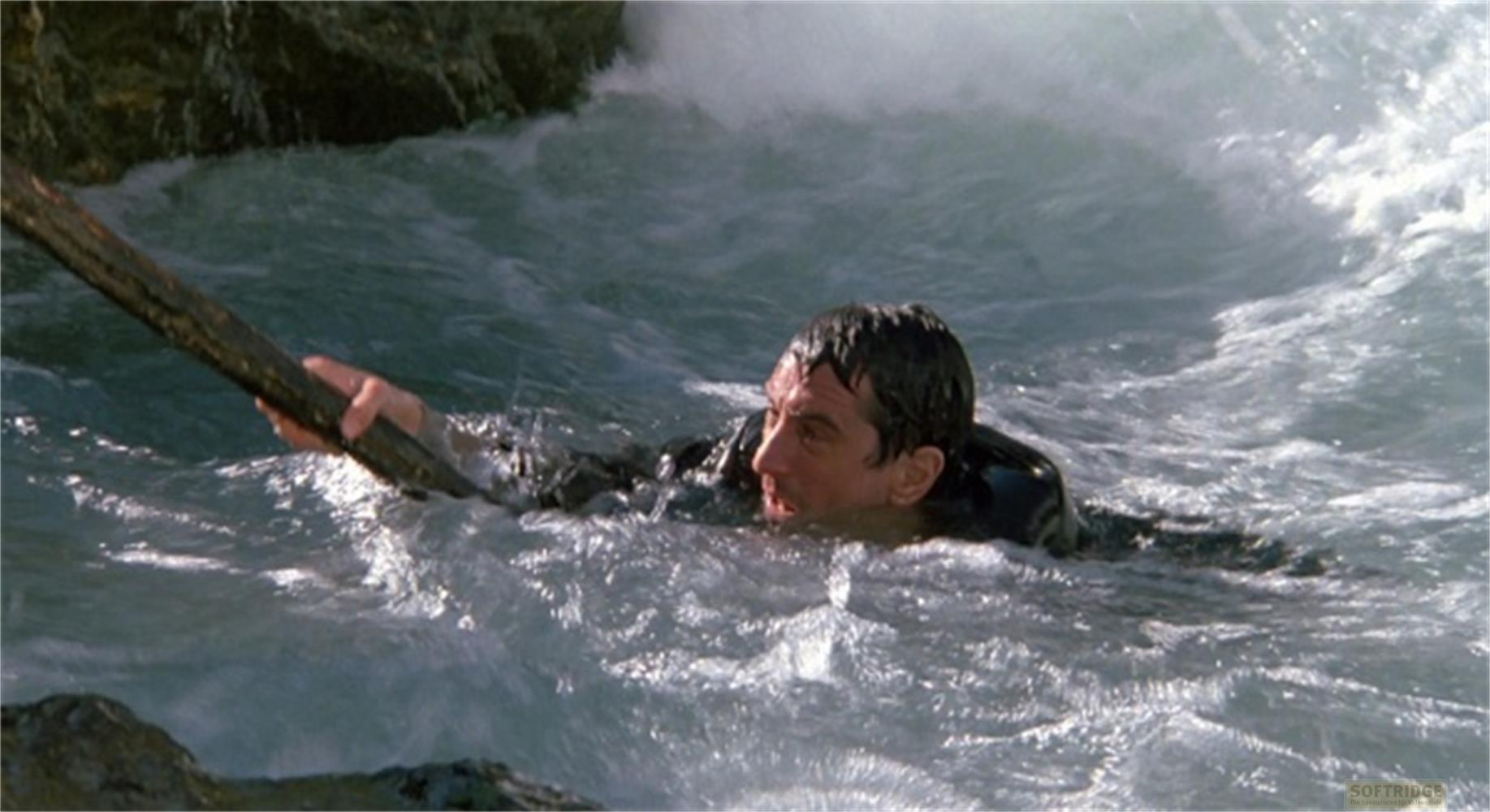 Un homme lutte dans une eau agitée, s'accrochant à une branche.