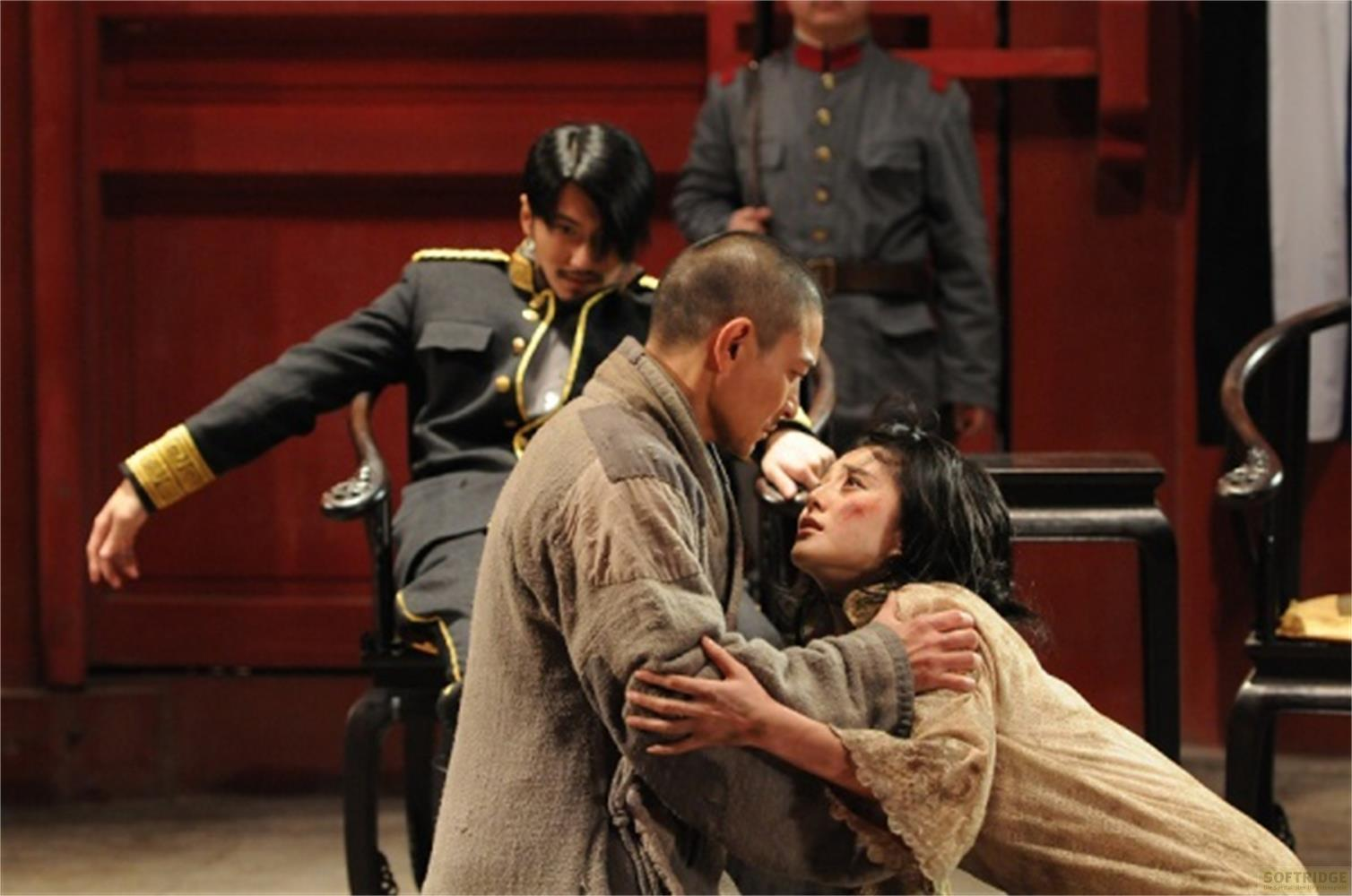 Un homme en uniforme est assis pendant qu'un homme enlace un autre homme et une femme.