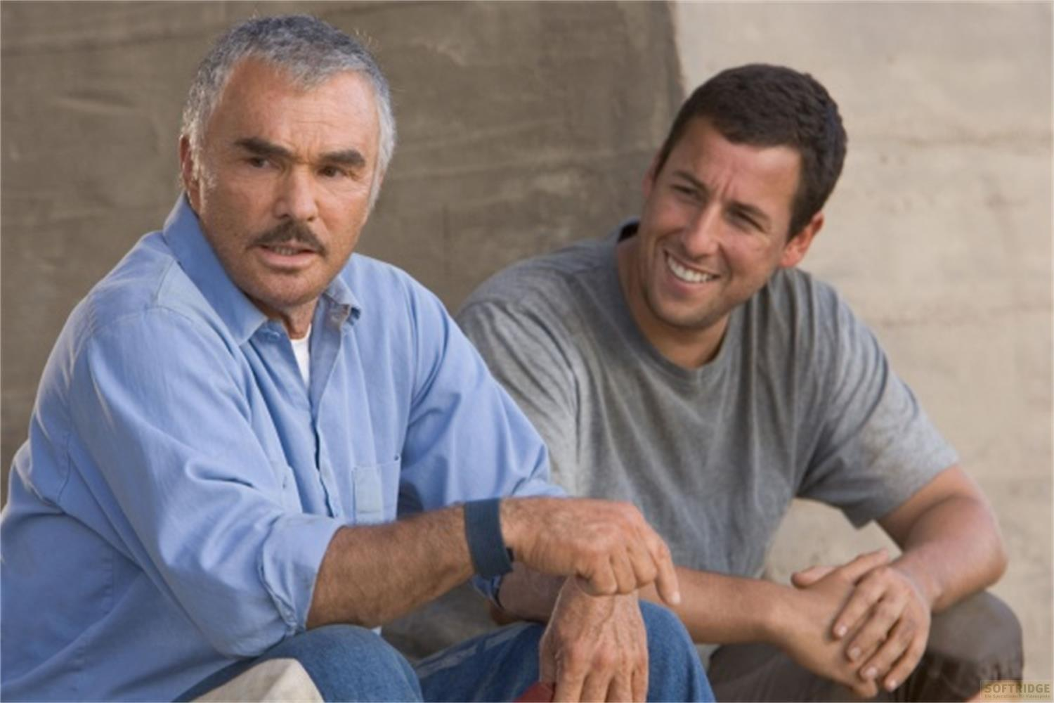 Deux hommes, un moustachu en chemise bleue, l'autre souriant en t-shirt gris.