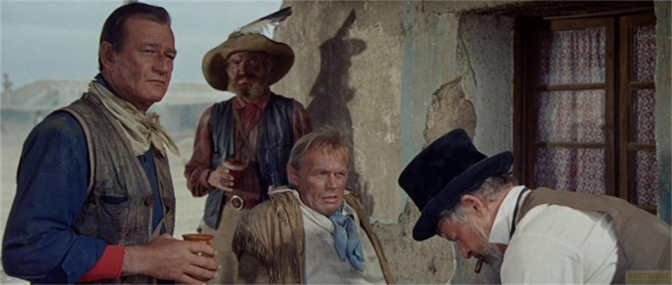 Quattro uomini in abiti western, uno seduto, gli altri in piedi.