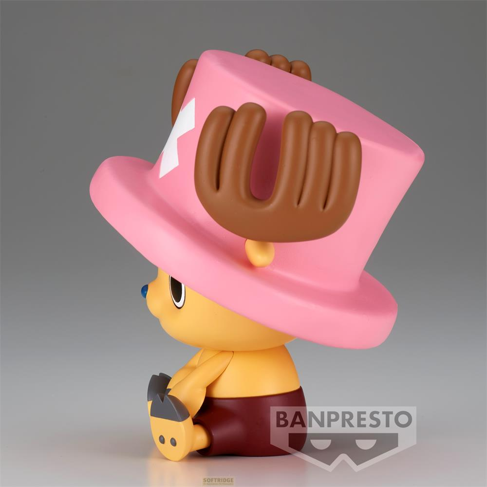 Una figura amarilla con un gran sombrero rosa se sienta con pantalones cortos marrones.