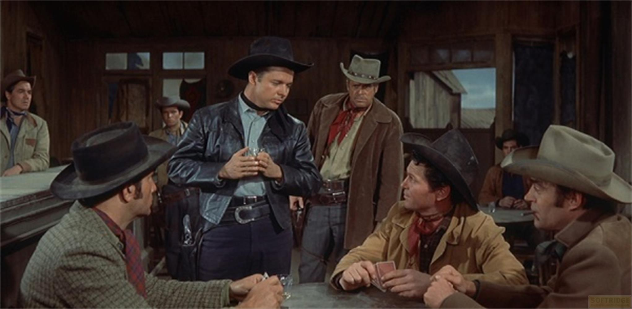 Uomini in un saloon, alcuni con cappelli e gilet, giocano a carte.