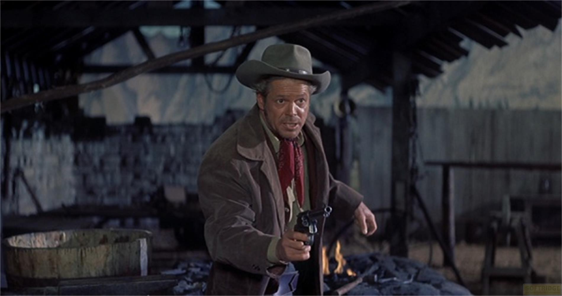Un uomo con cappello da cowboy e soprabito tiene una pistola, con fuoco dietro.
