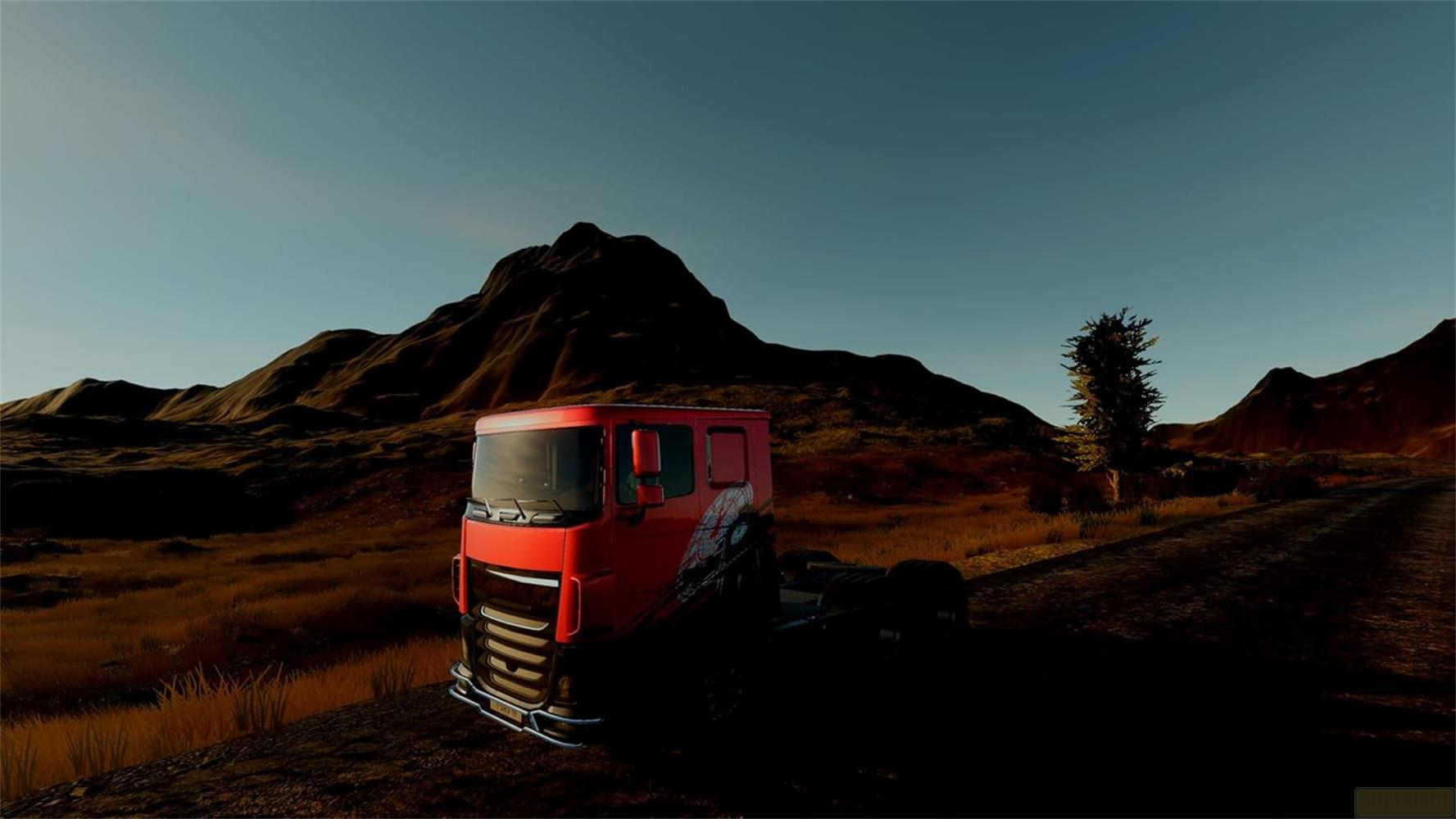 Ein roter LKW steht auf einem Feld mit trockenem Gras, Berge im Hintergrund.