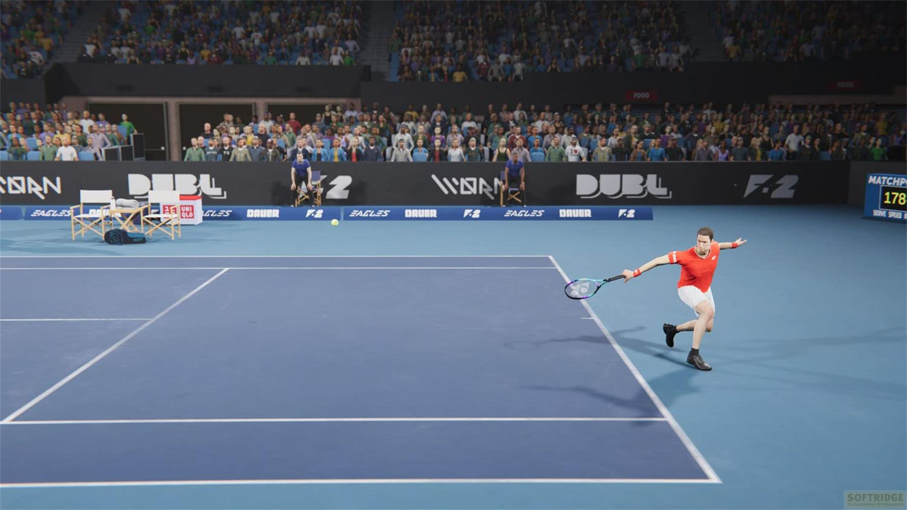 Ein Tennisspieler in Rot schlägt auf einem blauen Platz vor einem Publikum.