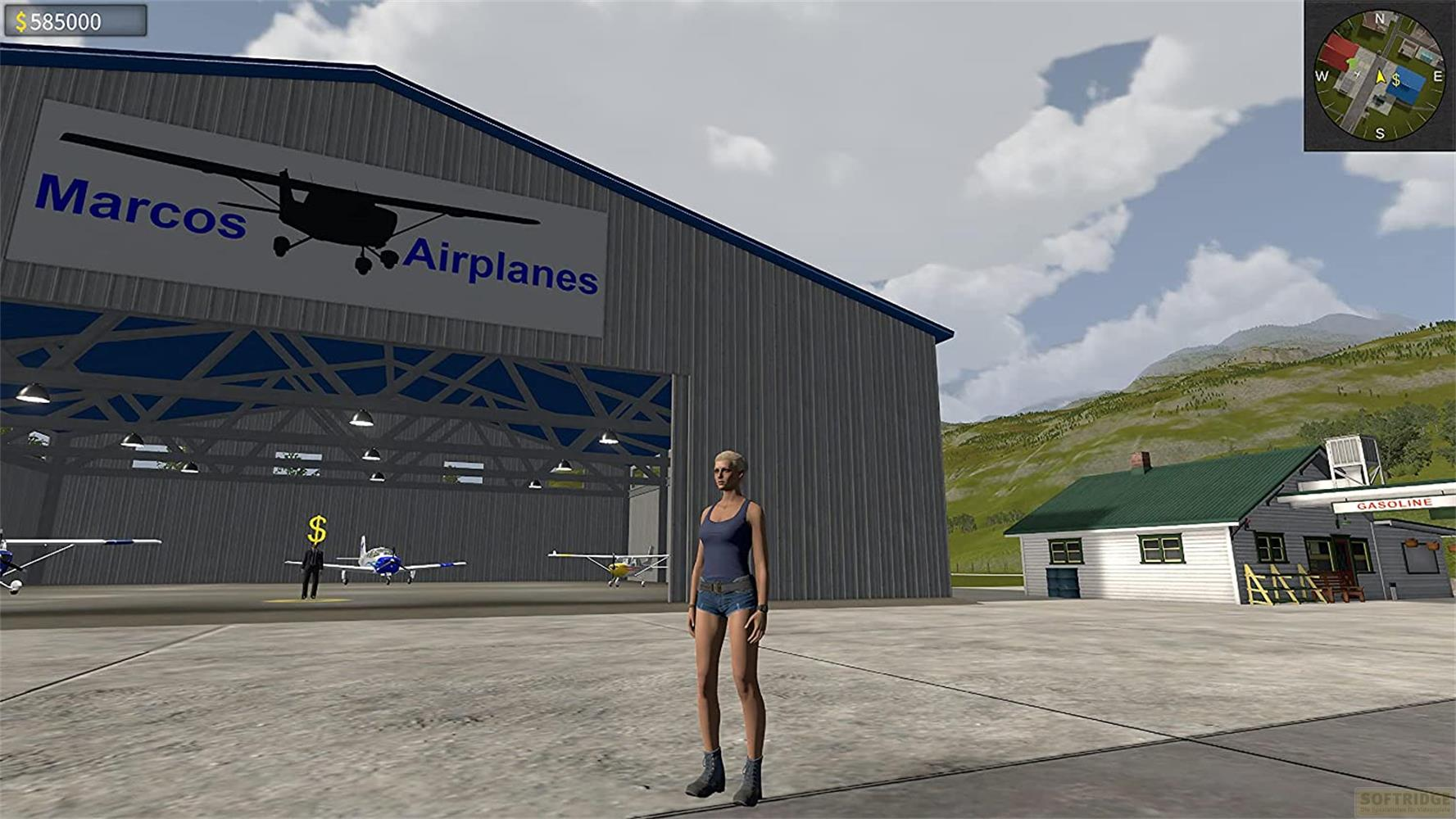 Eine Frau steht vor einem Hangar mit Flugzeugen, ein kleines Gebäude und Berge im Hintergrund.