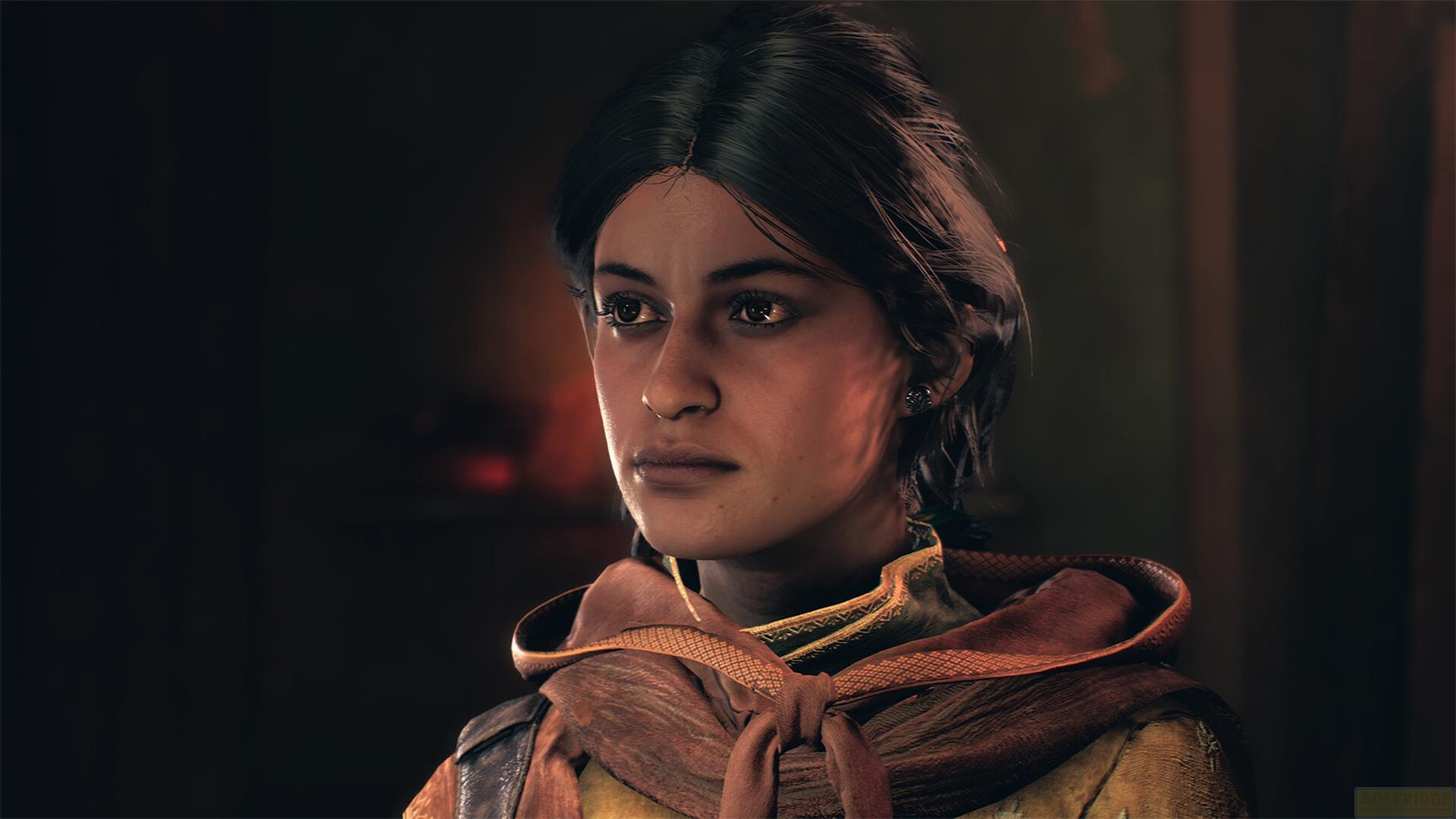 Eine junge Frau mit dunklem Haar und braunen Augen trägt einen orangefarbenen Schal.