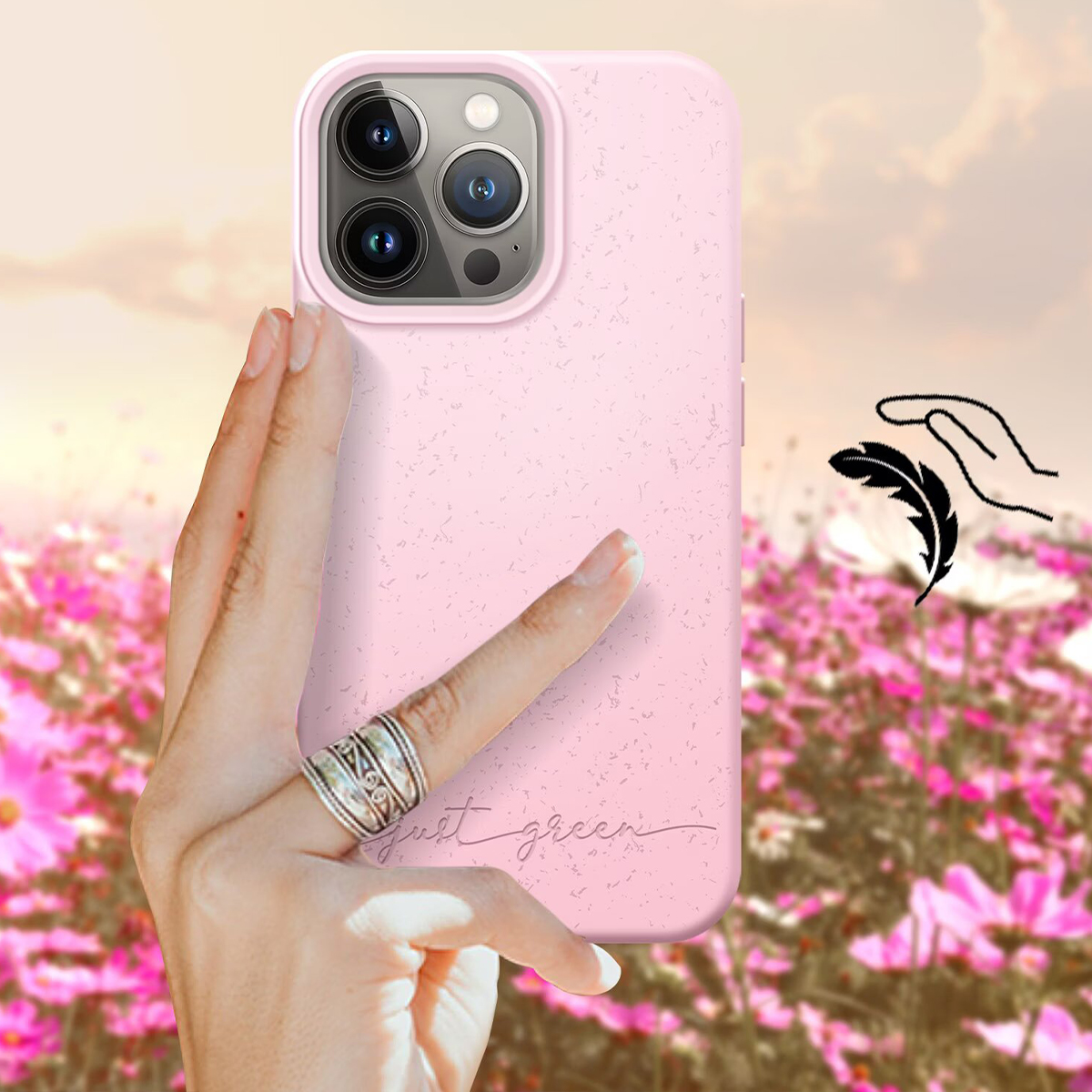 Eine Hand hält ein rosafarbenes Handy vor einer Blumenwiese im Sonnenuntergang.