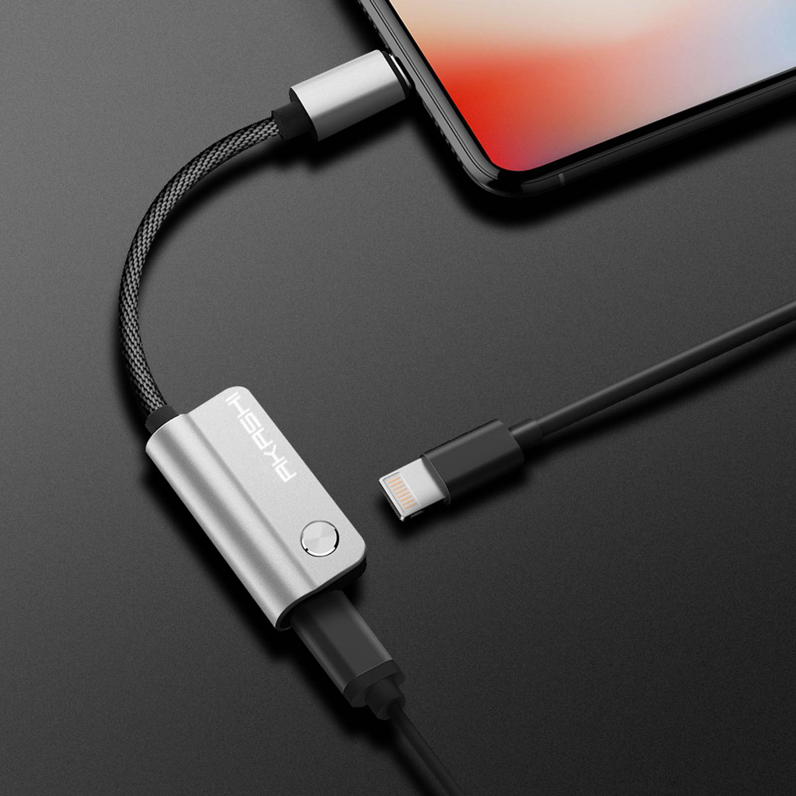 Un adaptateur argenté connecte un iPhone à un câble de chargement. Un autre câble est à côté.