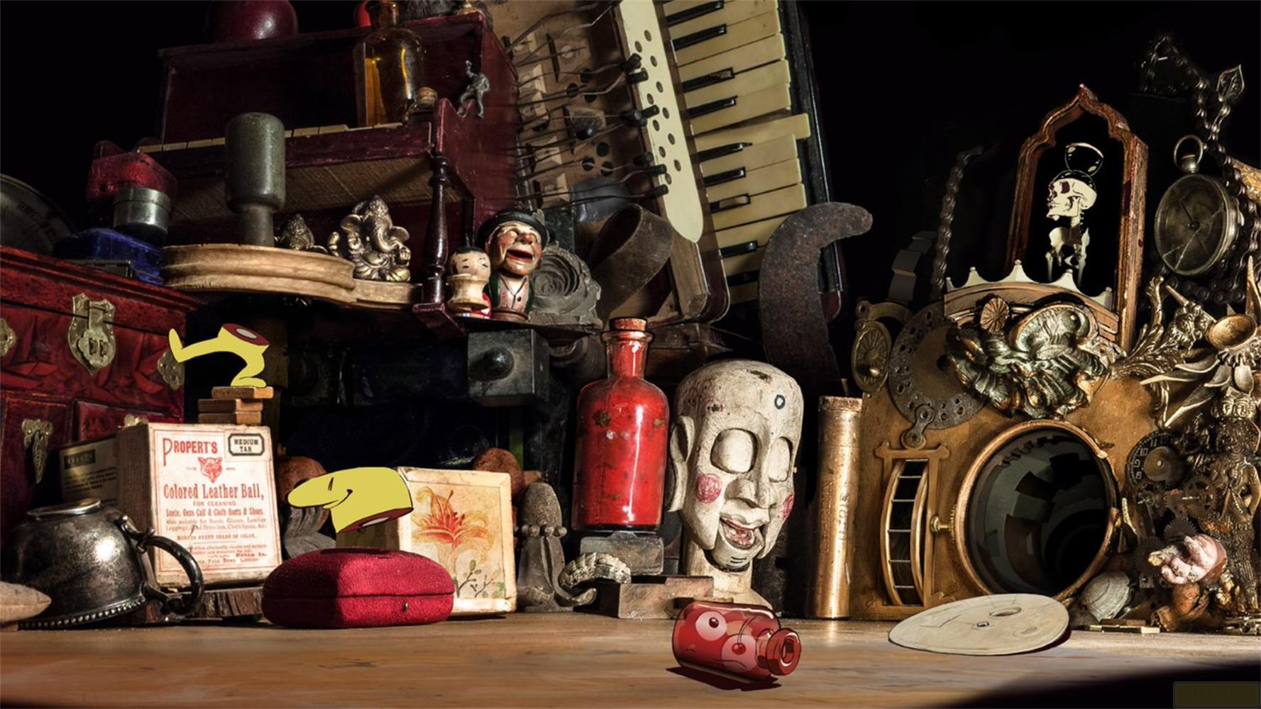 Eine Sammlung von Kuriositäten: eine rote Kiste, Totenköpfe, eine Flasche, eine Ziehharmonika und mehr.