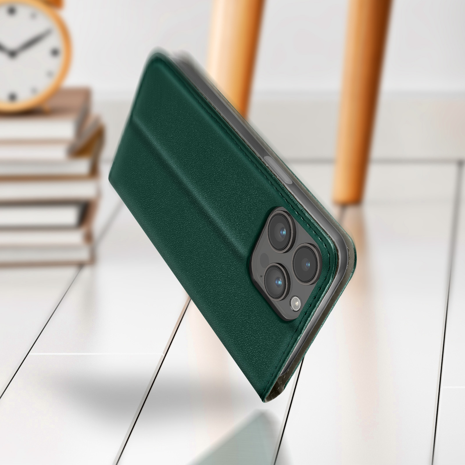 Custodia verde scuro per telefono con tre fotocamere su fondo legno.
