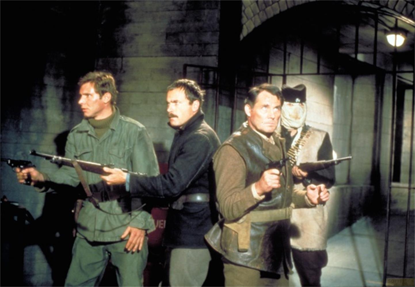 Quatre hommes armés se tiennent devant une porte. L'un porte une bandoulière.