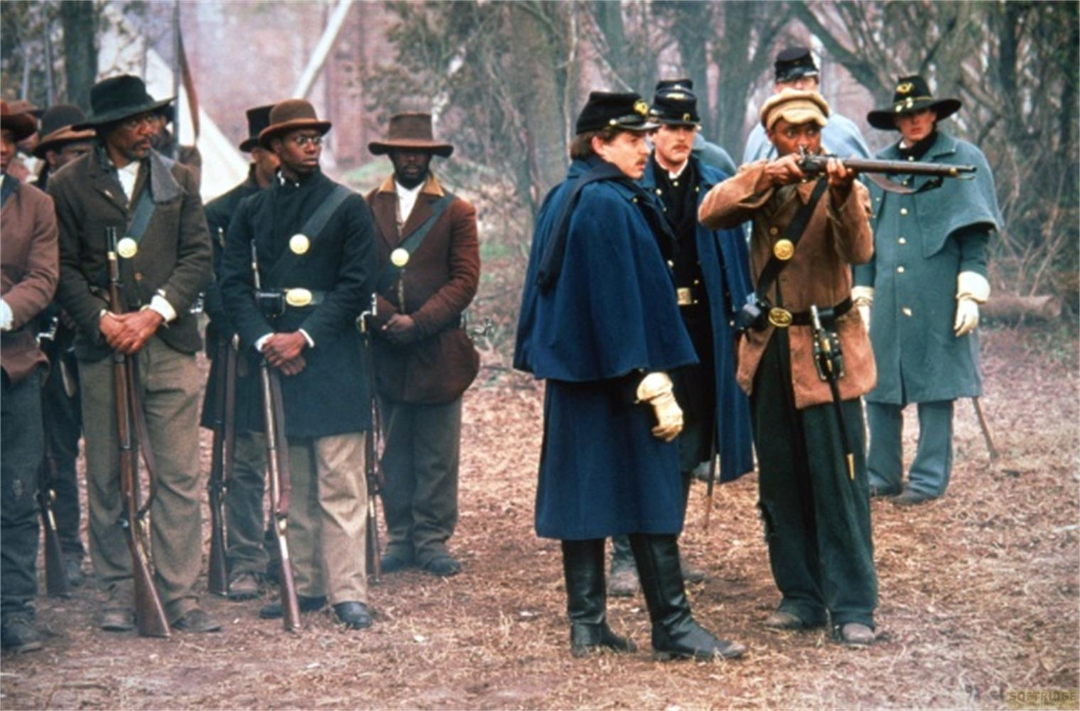 Militaires en uniformes historiques se tiennent dehors, certains tenant des fusils.