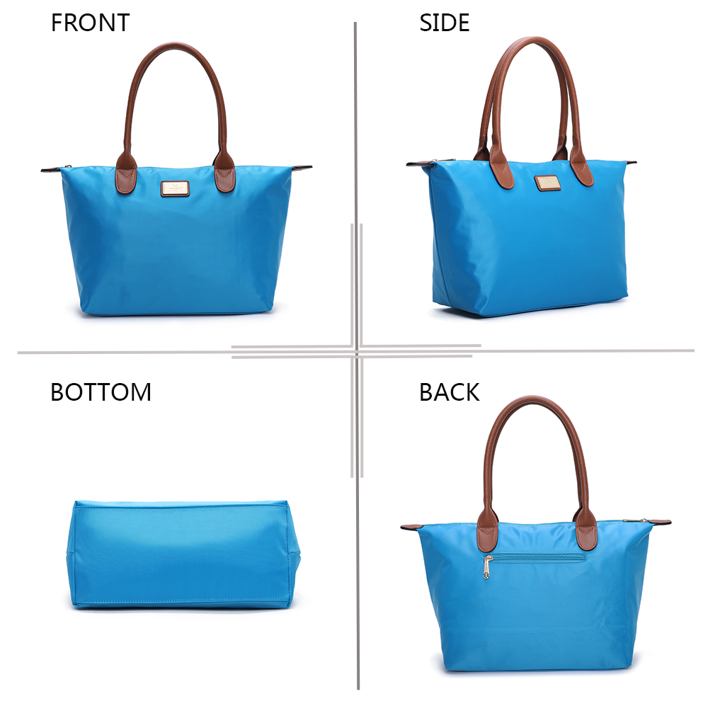 Bolso tote azul de tela con asas de cuero marrón, visto de frente, lado, base y atrás.