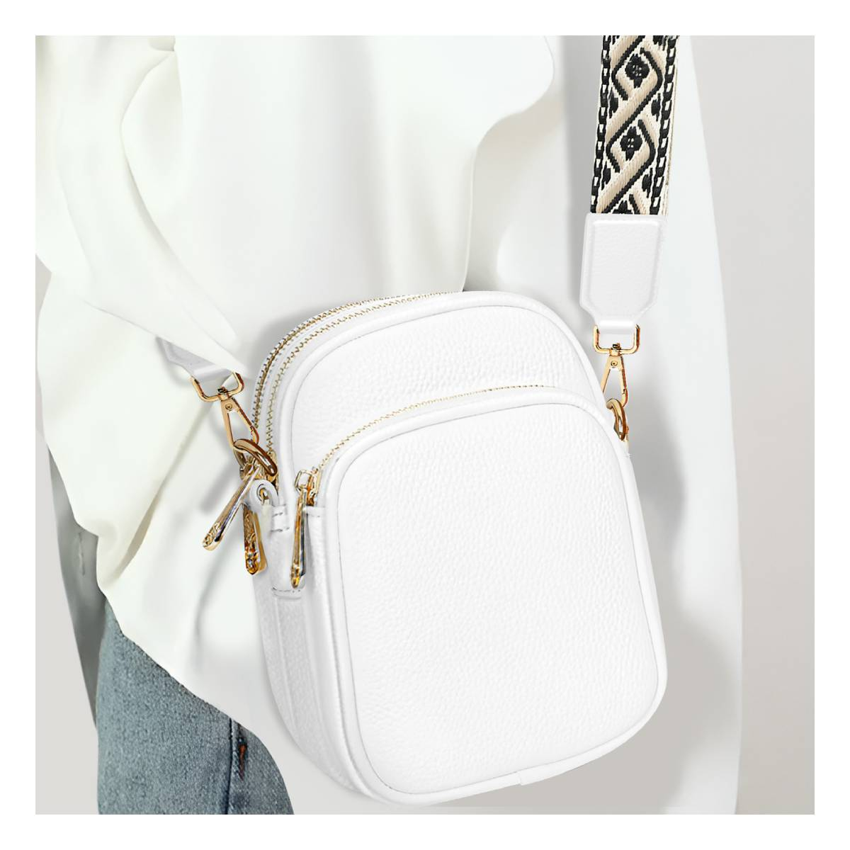Bolso cruzado blanco con dos bolsillos con cremallera y correa estampada.