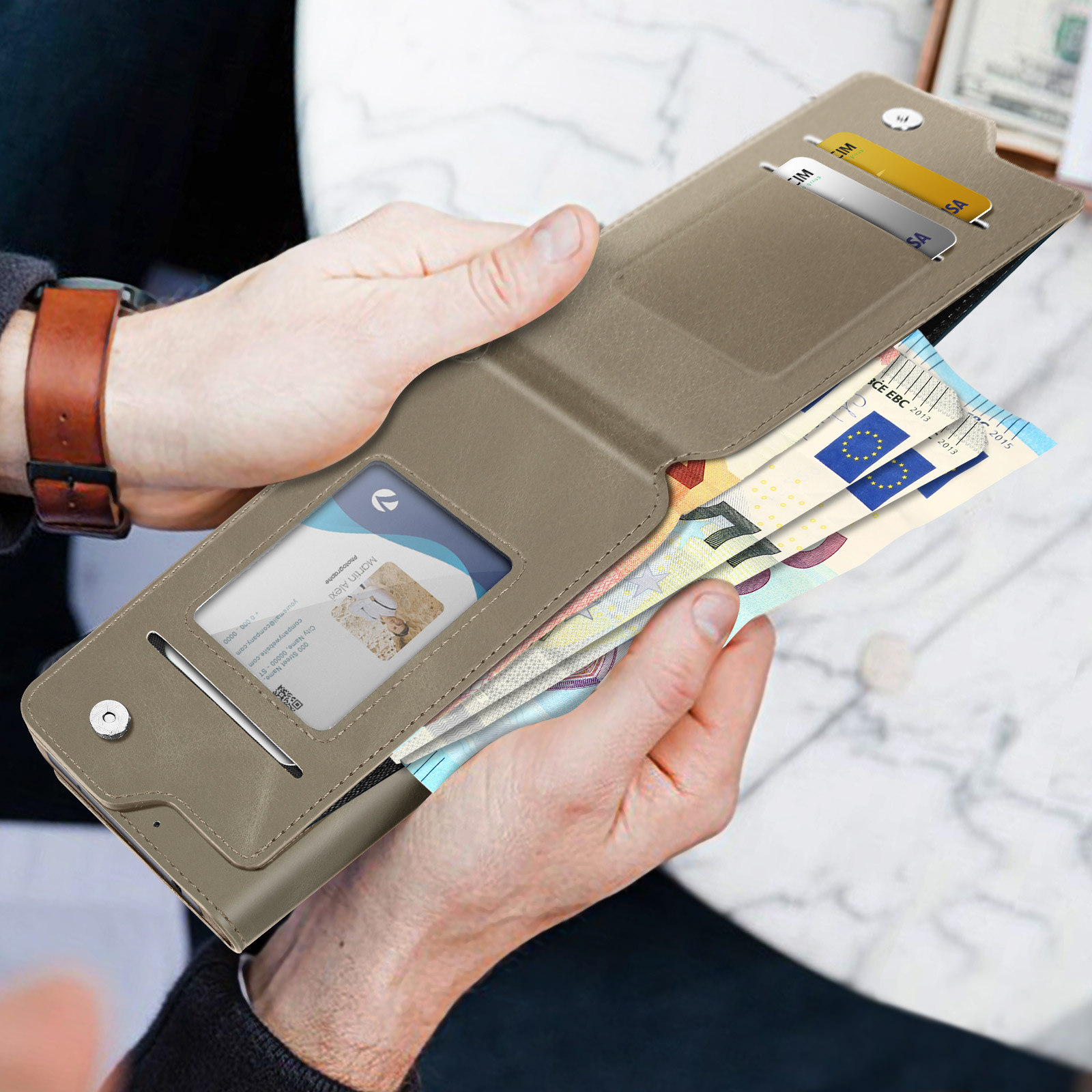 Una persona tiene un portafoglio marrone con banconote e carte.