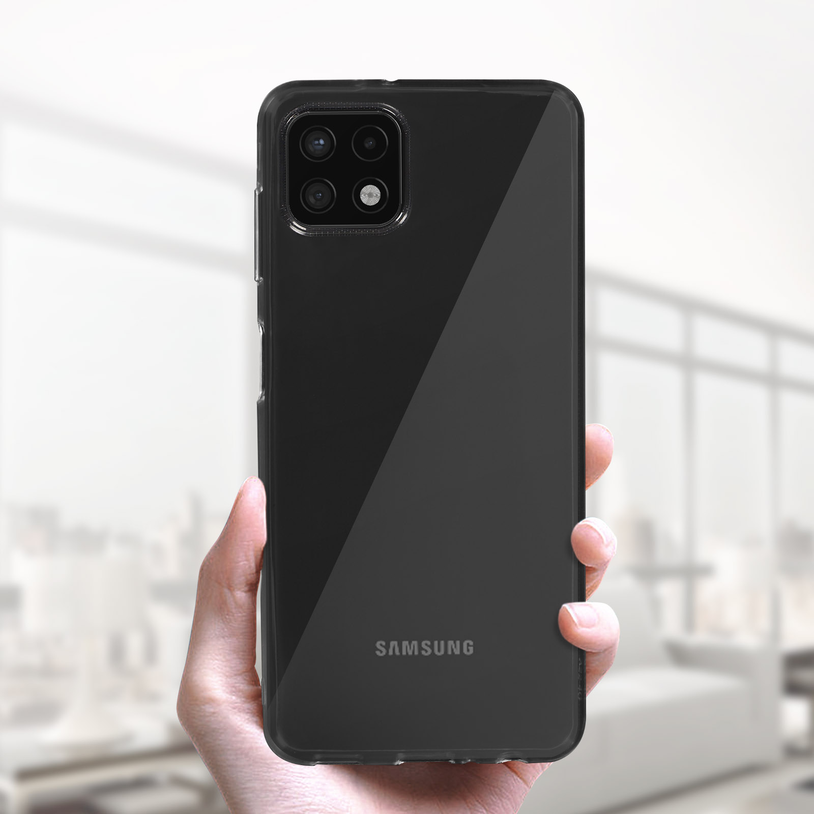 Una mano tiene un telefono Samsung nero con quattro fotocamere.