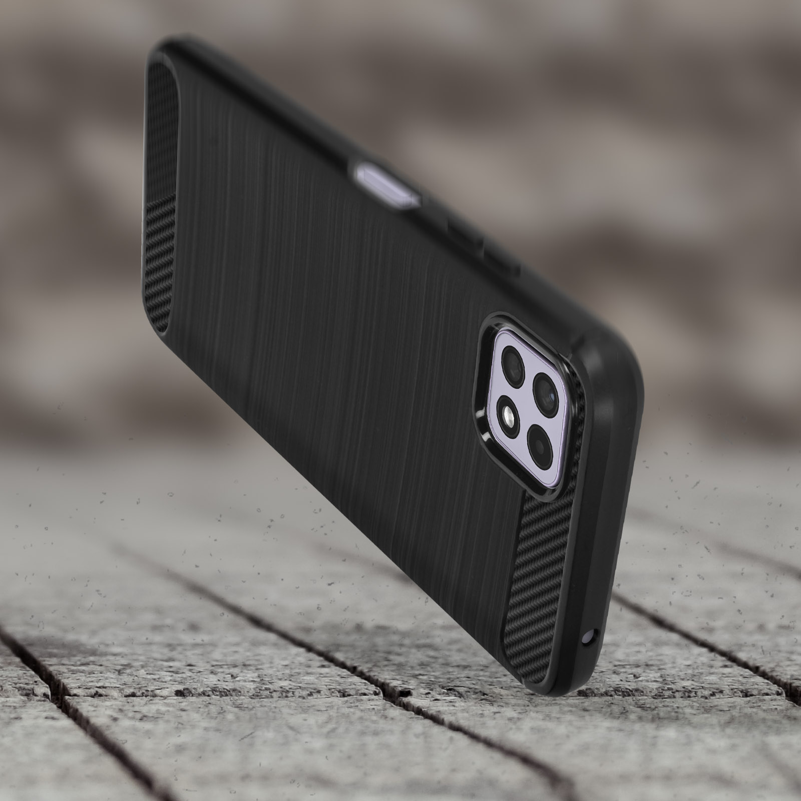 Cover nera per telefono con finitura spazzolata e accenti in carbonio su sfondo legno.