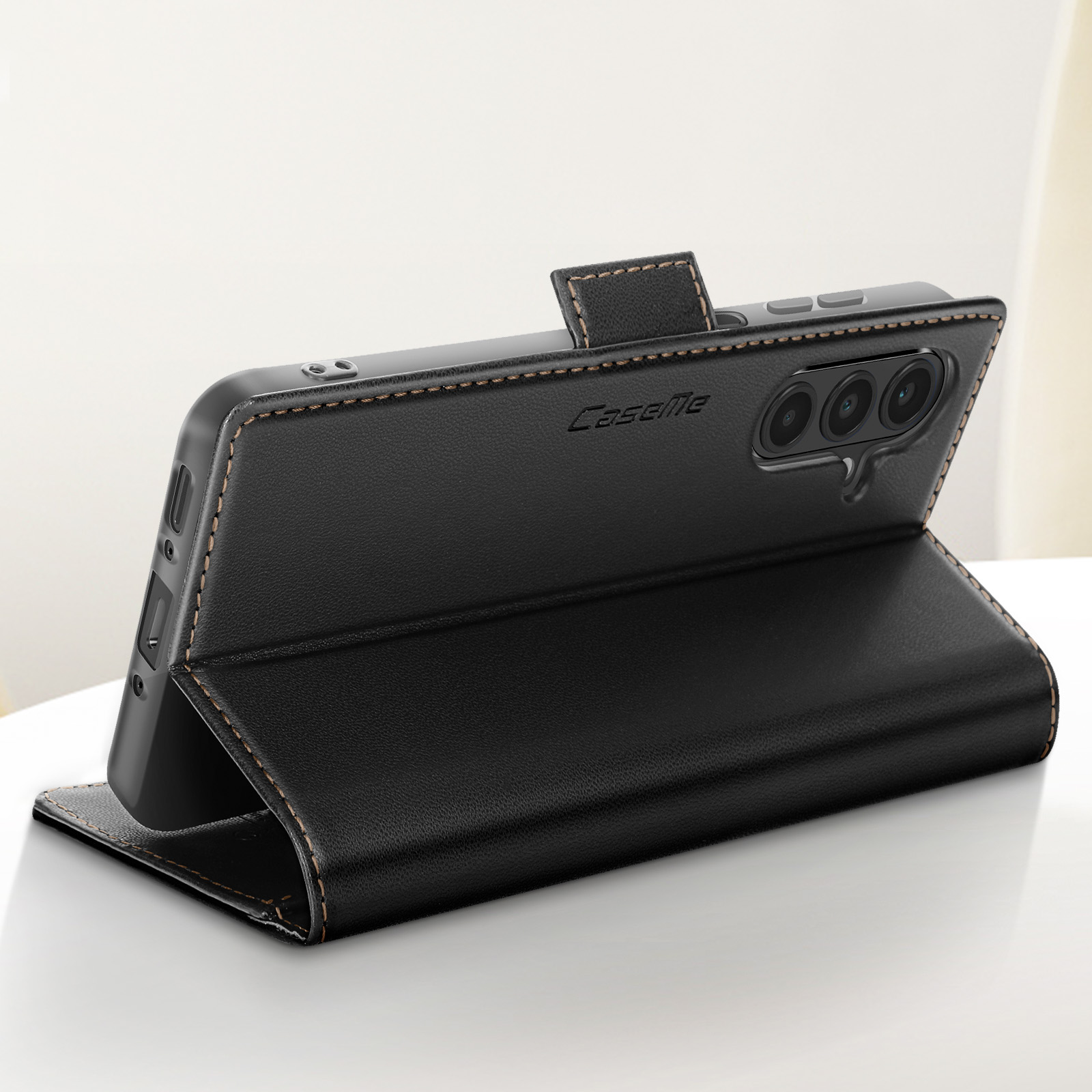 Custodia a libro in pelle nera per smartphone con tre fotocamere e cuciture.