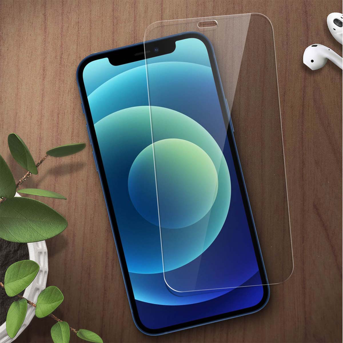 Een blauwe smartphone met schermprotector ligt op een houten tafel. Links een potplant.