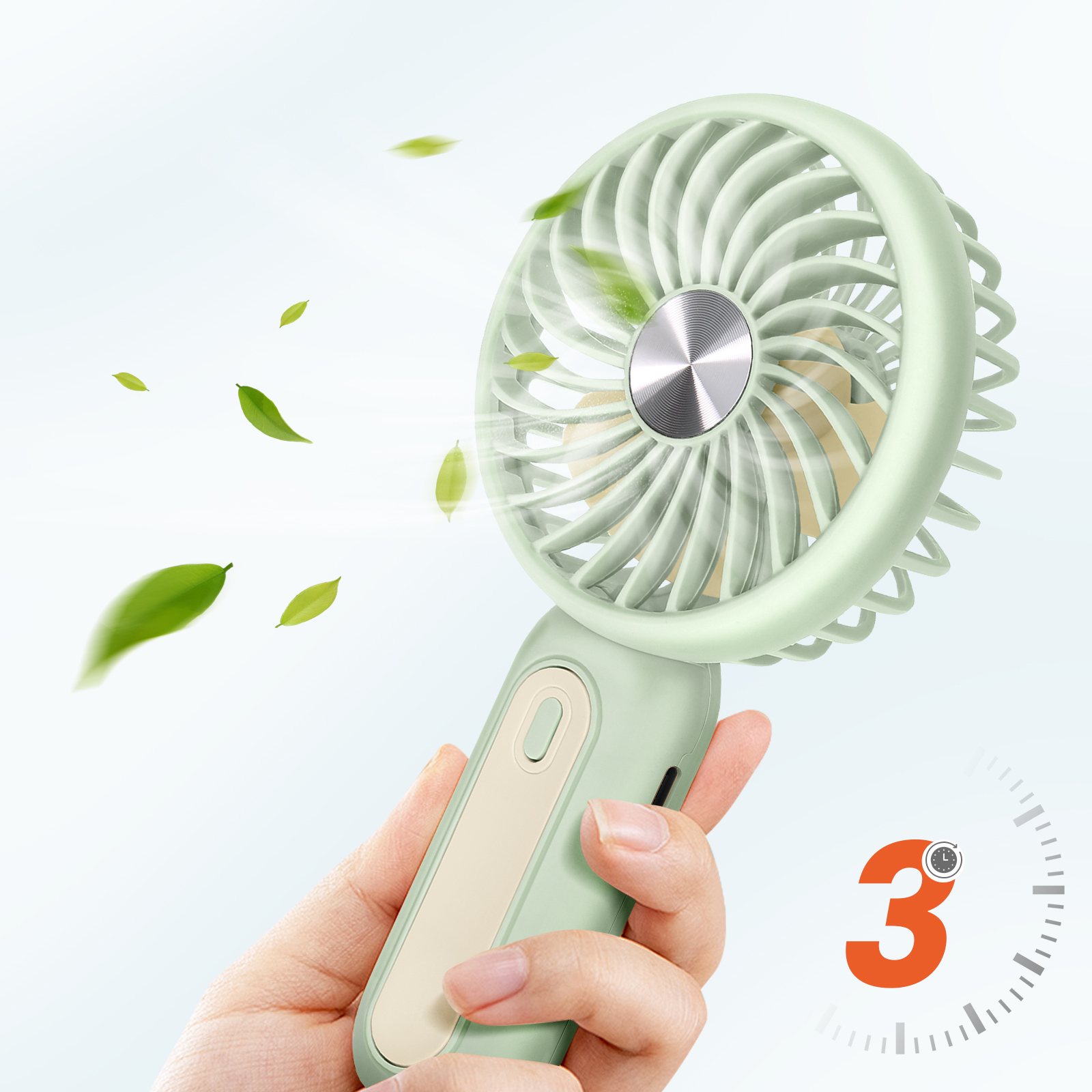 Una mano tiene un ventilatore verde chiaro con foglie che volano nell'aria.