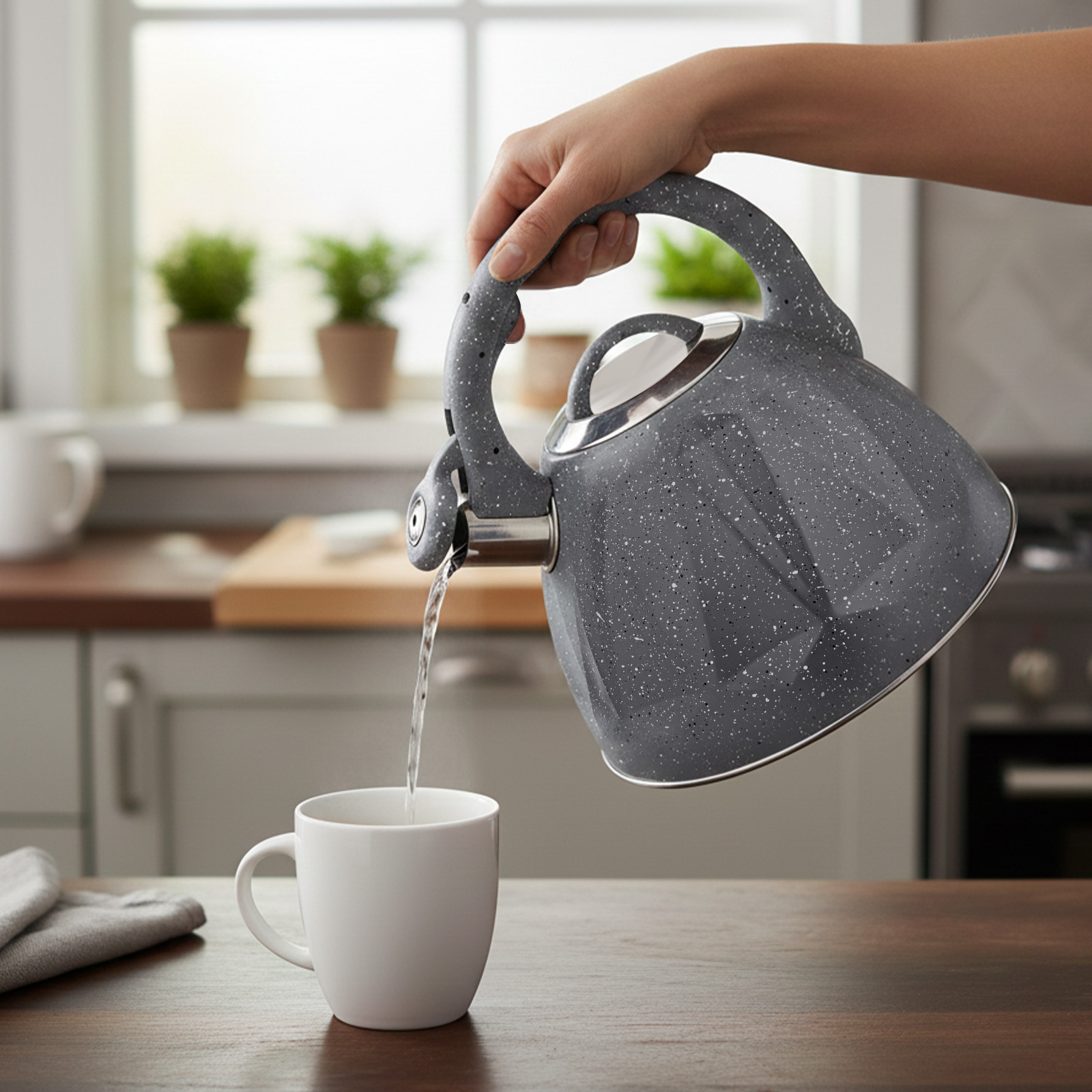 Graue Kanne gießt Wasser in eine weiße Tasse auf einem Holztisch.