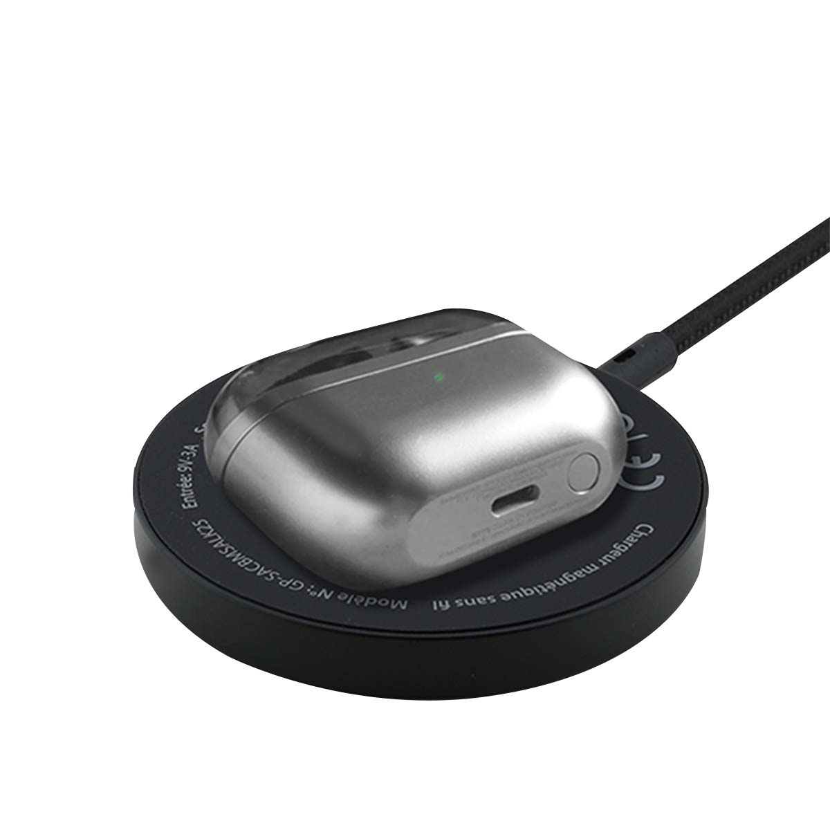 Una custodia argentata per auricolari senza fili poggia su un caricabatterie wireless nero.