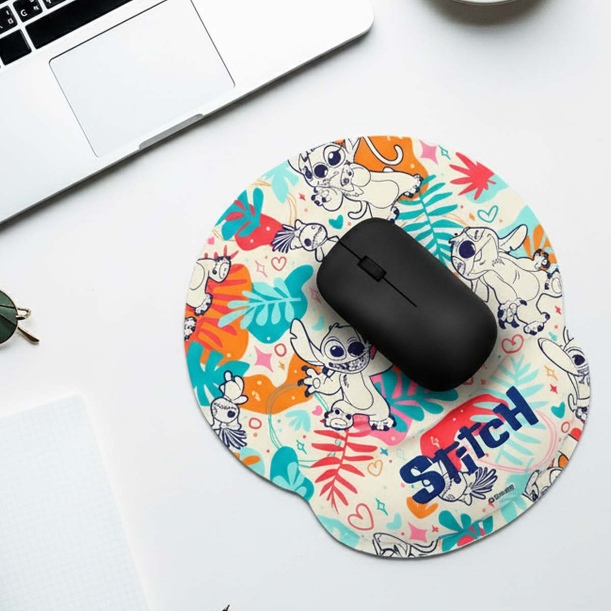 Mouse nero su tappetino Stitch con foglie colorate e personaggi.